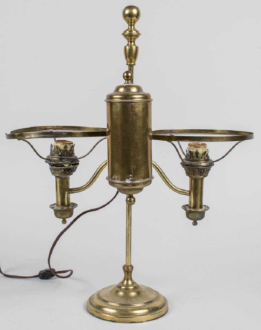 Brass Oil Lamp: Two light desk lamp, now electrified, no shades. Height 14 inches. Notice to bidders: Condition reports and additional photographs are provided by request as a courtesy to our clients, as such any con