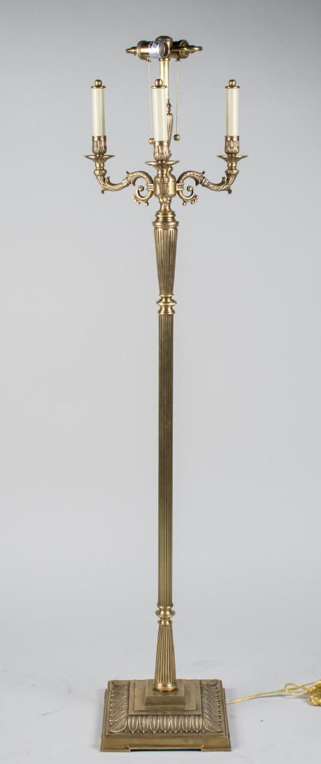 Brass Floor Lamp: Four scrolled candle arms centering a two light lamp. Height 5 feet. Notice to bidders: Condition reports and additional photographs are provided by request as a courtesy to our clients, as such any c