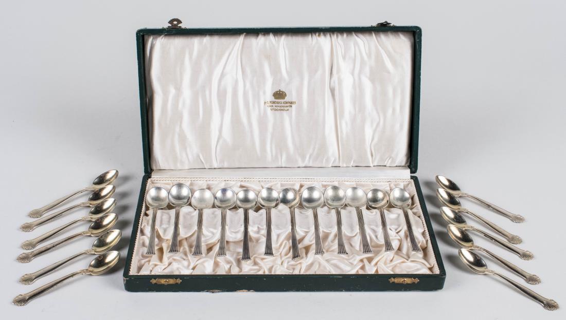 Two Sets of Coffee Spoons: Boxed set of twelve Swedish silver coffee spoons, maker CGH and a set of eleven silver plated coffee spoons with shell decoration. Total 104 grams. Notice to bidders: Condition reports and additional