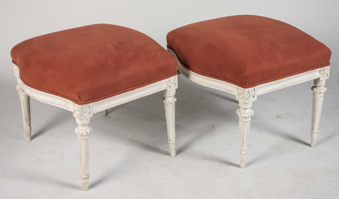 Pair of Louis XVI Style Painted Footstools: White painted stools, with rust upholstery. Height 17 inches, width 21 inches, depth 20 inches. Notice to bidders: Condition reports and additional photographs are provided by request as a courtesy to