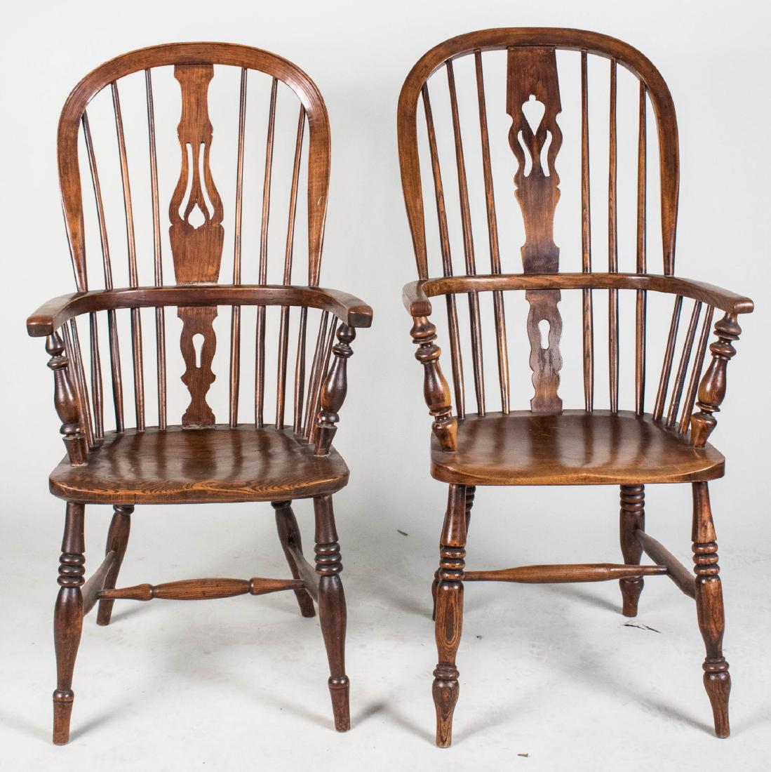 Two Windsor Chairs: Spindle back armchairs with pierced vertical splats, panel seats and turned legs joined by H stretchers. Height 43 inches, width 22 inches, depth 25 inches. Notice to bidders: Condition reports and ad