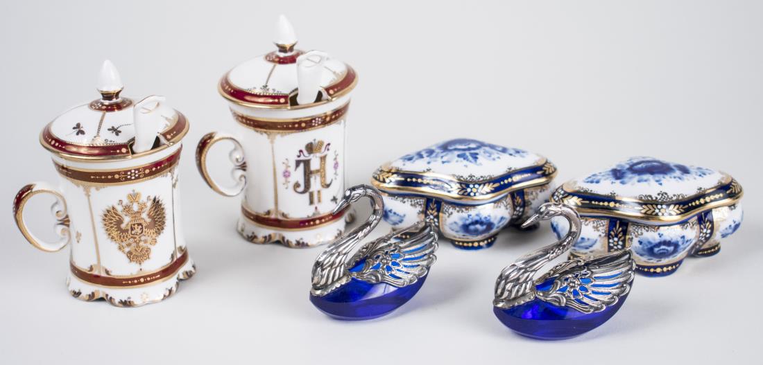 Group of Table Decorations: Comprising a pair of Russian ceramic covered cups with spoons, a pair of silver plated cobalt glass swan salt cellars and a pair of porcelain trinket boxes. Cups, height 5 1/4 inches. Notice to bidder