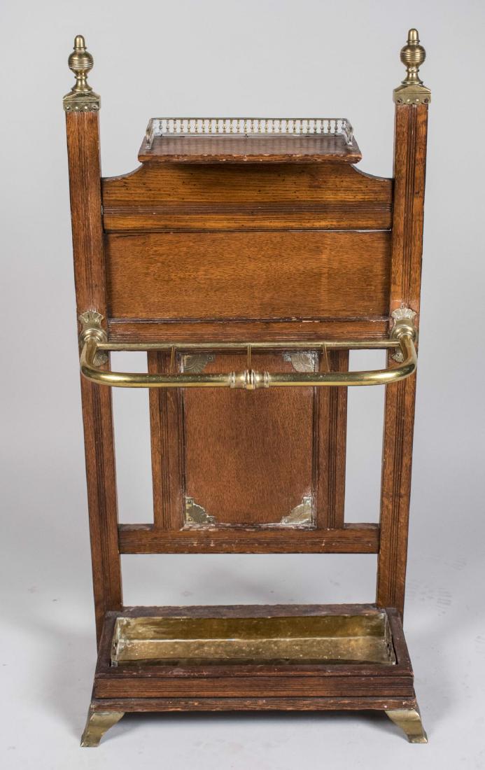 Oak Hall / Umbrella Stand: Panel back with surmounted by a vide poche, with brass coat rack at the center. Height 44 inches, width 22 inches, depth 6 inches. Notice to bidders: Condition reports and additional photographs are p