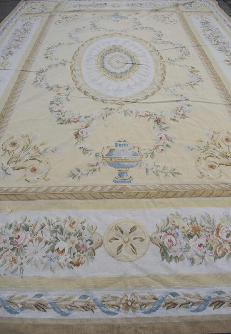 Sino-Aubusson Carpet: Center medallion on a light yellow field, within a light yellow and ivory border, allover floral swag, scroll and urn decoration. 15 feet 8 inches x 10 feet 8 inches. Notice to bidders: Condition repo