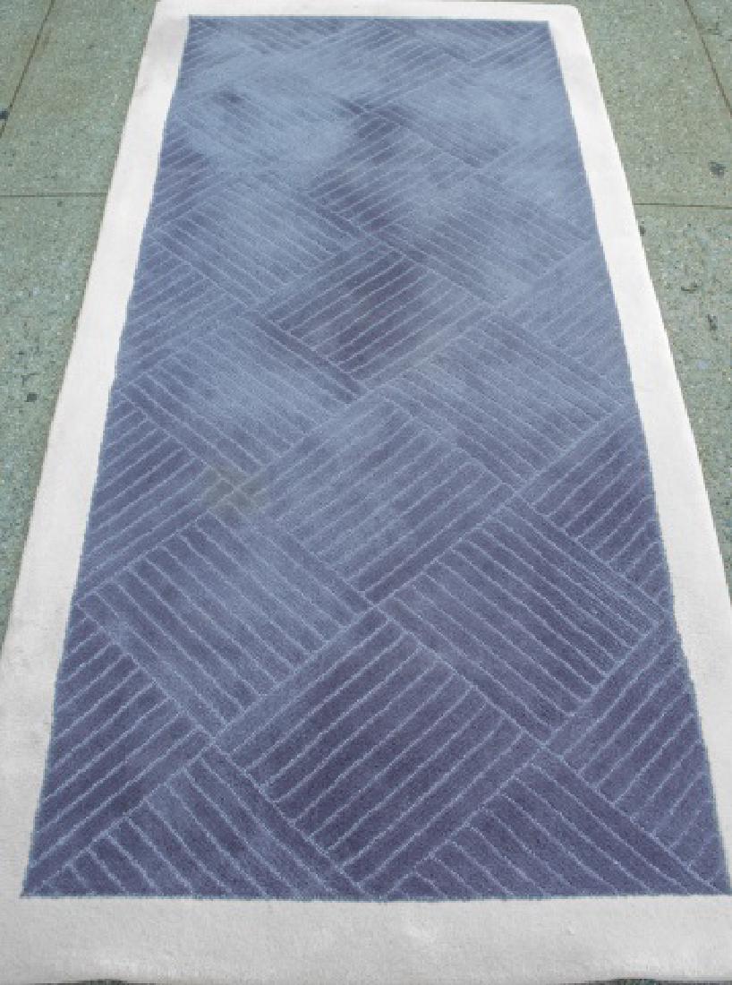 Edward Fields Carpet: Allover purple geometric pattern, within an ivory border. 6 feet 11 inches x 3 feet 3 inches. Notice to bidders: Condition reports and additional photographs are provided by request as a courtesy to o