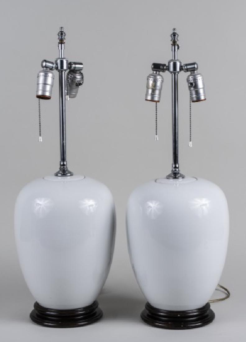 Pair of White Porcelain Lamps: Each a two light lamp with ovoid jar body. Base height 12 1/2 inches. Notice to bidders: Condition reports and additional photographs are provided by request as a courtesy to our clients, as such any 