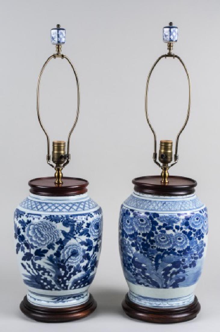 Pair of Blue and White Porcelain Lamps: Two jar form single light lamps each with floral decoration. Base height 13 3/4 inches. Notice to bidders: Condition reports and additional photographs are provided by request as a courtesy to our cli