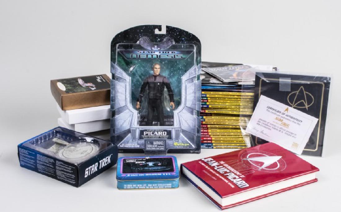 Group of Star Trek The Next Generation Memorabilia: Including magazines, medals, scale models, a Captain Jean-Luc Picard action figure, commemorative stamps, and a copy of Jean-Luc Picard's autobiography. Notice to bidders: Condition reports and additi