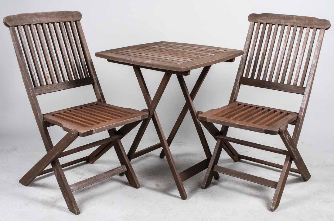Two Slatted Chairs and Table: Foldable table and pair of chairs Table, height 28 inches, 23 inches square Notice to bidders: Condition reports and additional photographs are provided by request as a courtesy to our clients, as suc