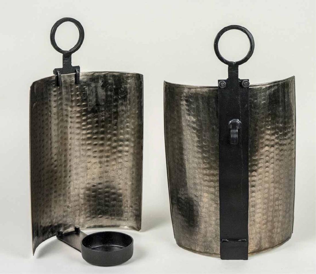 Pair of Metal Sconces: Single light candle sconces with hammered finish metal shades Height 15 1/2 inches Notice to bidders: Condition reports and additional photographs are provided by request as a courtesy to our clients,
