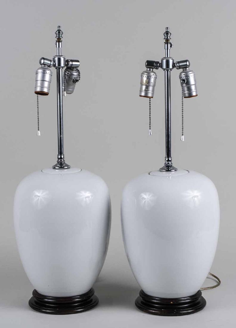 Pair of White Porcelain Lamps: Each a two light lamp with ovoid jar body. Base height 12 1/2 inches. Notice to bidders: Condition reports and additional photographs are provided by request as a courtesy to our clients, as such any 