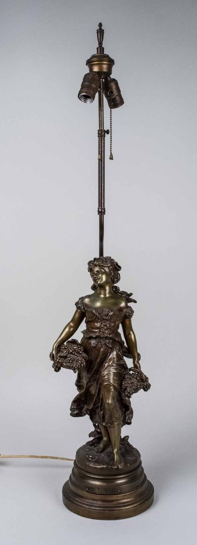 Bronze Figural Lamp: Two light lamp, modelled as a young woman carrying a basket of grapes. Figure, height 20 1/2 inches. Notice to bidders: Condition reports and additional photographs are provided by request as a courte