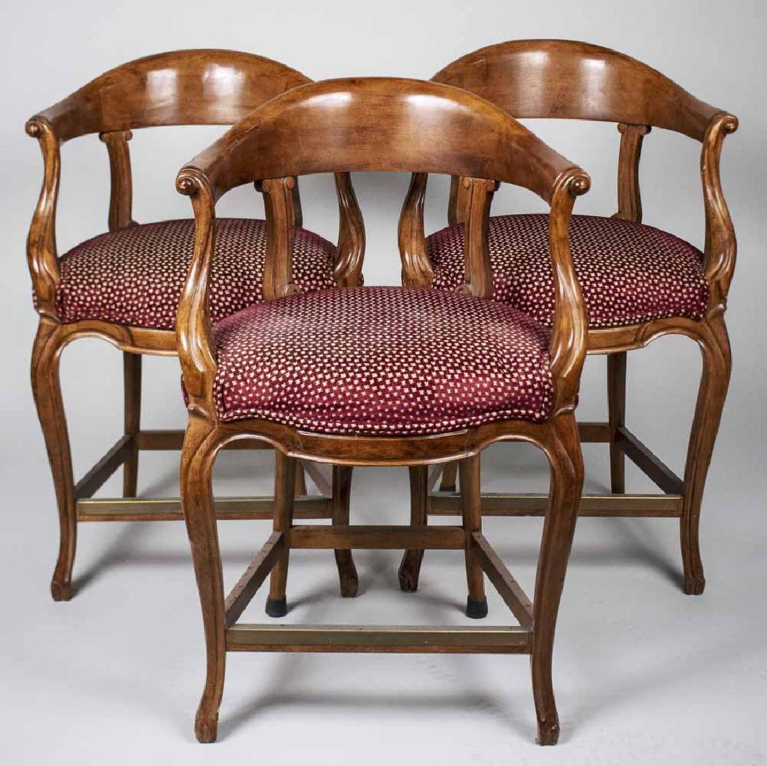 Set of Three Barstools: Arched top tablet crest rails, open arms, upholstered seats, on cabriole legs joined by a box stretcher. Height 38 inches, width 25 inches, depth 24 inches. Notice to bidders: Condition reports and ad