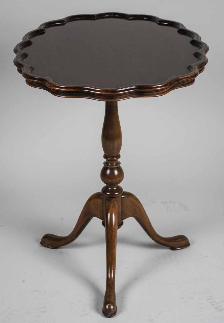 Pie Crust Oval Top Tripod Table: Oval top with scalloped edge, on a turned support on three scrolled legs. Height 27 inches, width 29 inches, depth 21 inches. Notice to bidders: Condition reports and additional photographs are provid