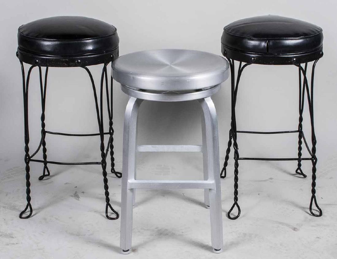 Three Stools: Including a pair of wire frame stools with black vinyl upholstered seats, and a brushed aluminum shop stool. Pair, height 27 1/2 inches, diameter 14 1/4 inches. Notice to bidders: Condition reports an