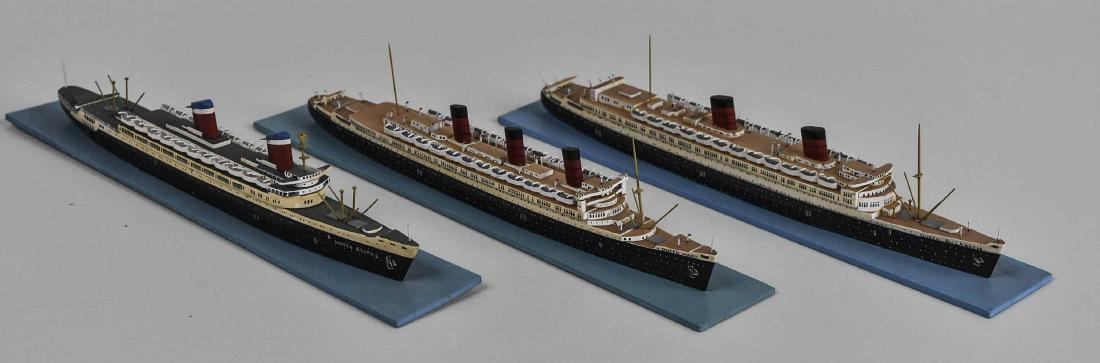Three Miniature Model Wood Ocean Liners: Including the RMS Queen Mary, the RMS Queen Elizabeth, and the SS United States, on stands. Length of stand 10 1/4 inches. Notice to bidders: Condition reports and additional photographs are provided 