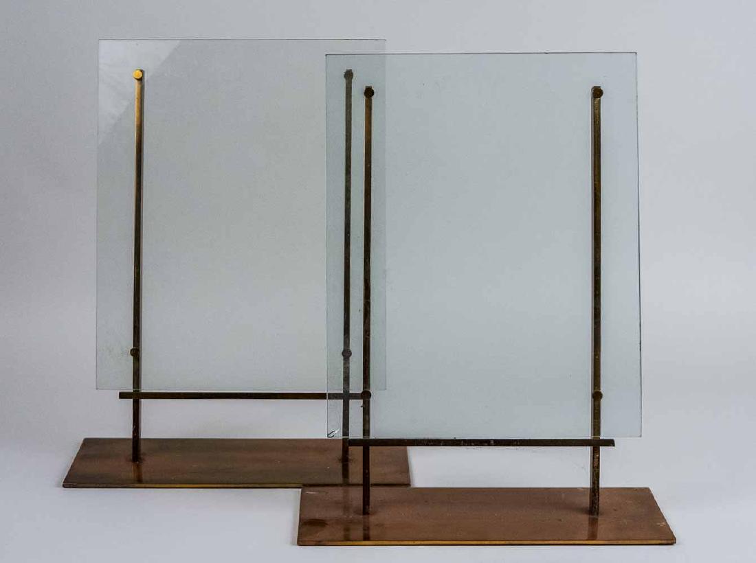Pair of Glass Picture Frames: On brass stands. Height 19 1/2 inches. Notice to bidders: Condition reports and additional photographs are provided by request as a courtesy to our clients, as such any condition report is only an opi