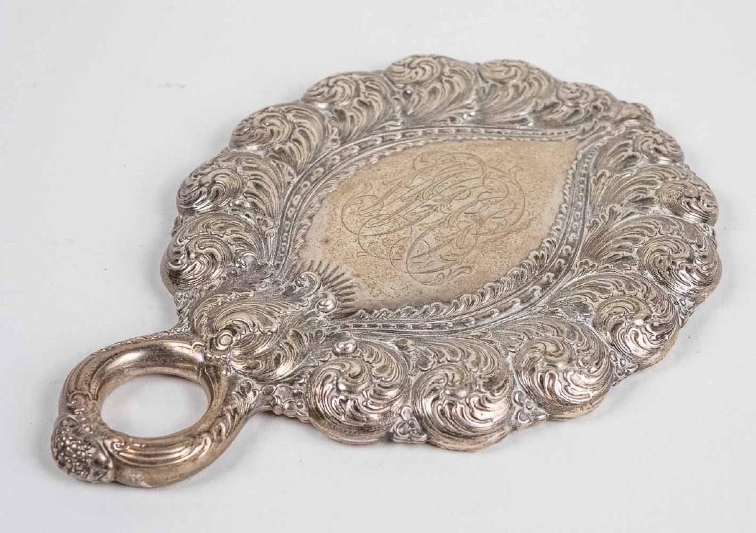 Sterling Silver Dresser Hand Mirror: Scroll and flower decoration, marked Tiffany (partially visible). Notice to bidders: Condition reports and additional photographs are provided by request as a courtesy to our clients, as such any cond