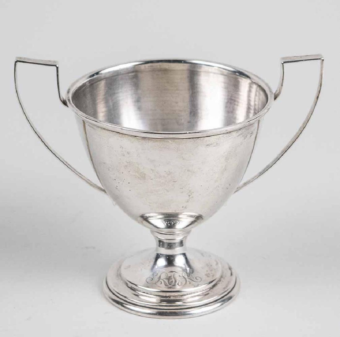 Sterling Silver Trophy Cup: Two handle pedestal cup. Height 5 1/4 inches, 260 grams. Notice to bidders: Condition reports and additional photographs are provided by request as a courtesy to our clients, as such any condition rep