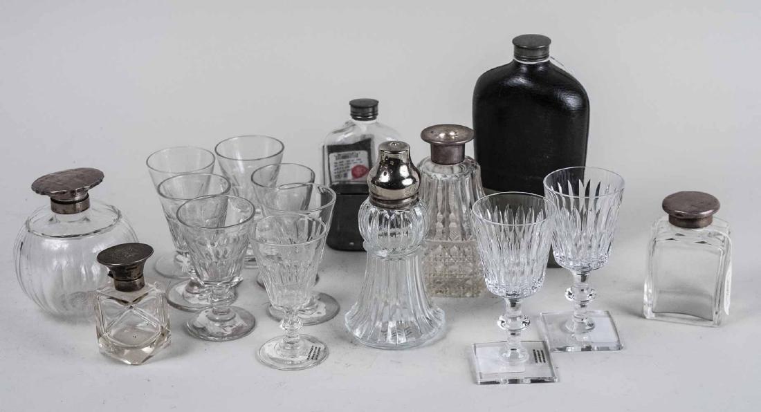 Group of Bottles, Flasks and Glasses: Glass bottles with sterling tops, two flasks and a set of small bar glasses. Tallest, height 8 inches. Notice to bidders: Condition reports and additional photographs are provided by request as a cour