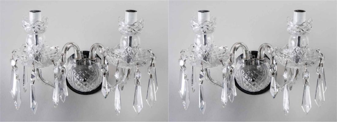 Pair of Molded Glass Sconces: Each a two light sconce with scrolled arms issued from a round back plate, and crystal prism decoration. Notice to bidders: Condition reports and additional photographs are provided by request as a co