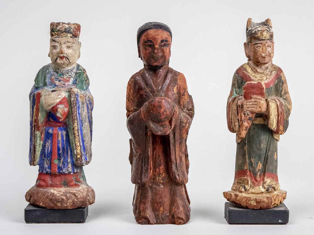 Three Korean Carved Wood Figures: Each modeled standing, with polychrome painted decoration. Notice to bidders: Condition reports and additional photographs are provided by request as a courtesy to our clients, as such any condition r