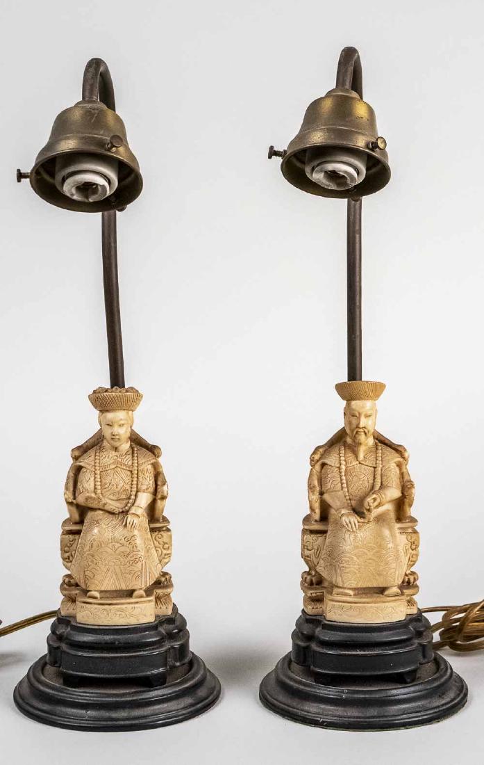 Pair of Chinese Style Faux Ivory Table Lamps: Modeled as an Emperor and Empress, each seated on a throne. Overall, height 16 inches. Notice to bidders: Condition reports and additional photographs are provided by request as a courtesy to our clie