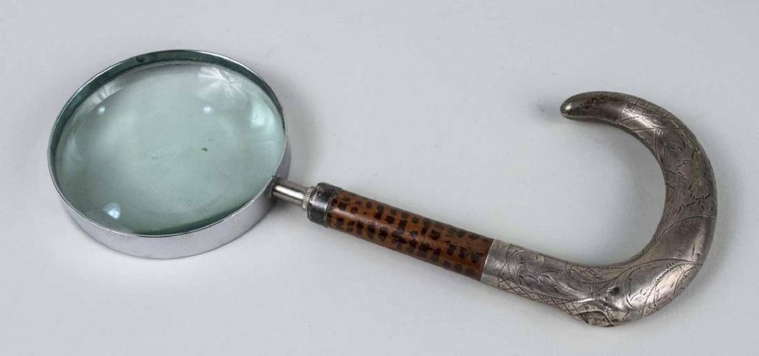 Hand Magnifier: Sterling silver cane style handle with incised floral, scroll, and lattice decoration. Height 11 inches. Notice to bidders: Due to the nature of this particular online sale, the lots offered may not b
