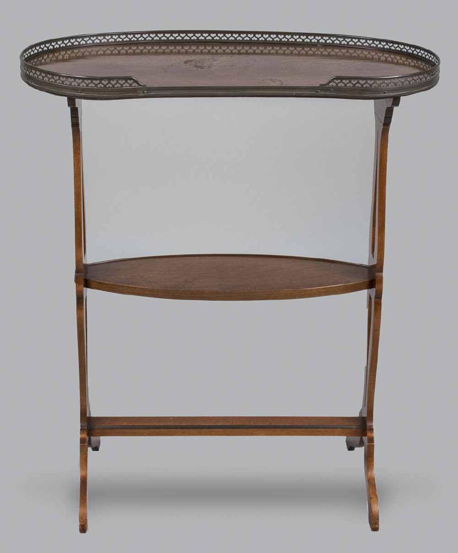 Reniform Trestle Table: Reniform top with brass 3/4 gallery, on two openwork scrolled supports with a medial oval shelf and trestle base. Height 30 inches, width 26 inches, depth 14 inches. Notice to bidders: Due to the natu