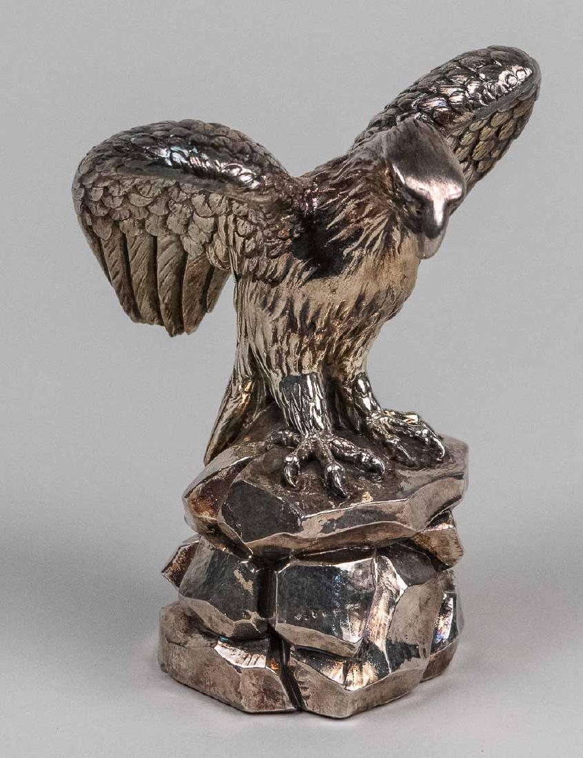A Giannelli Silver Clad Spread Winged Eagle: Bonded alabaster and marble with silver overlay figure, modelled perched on rocks. Height 7 1/4 inches. Notice to bidders: Condition reports and additional photographs are provided by request as a cou