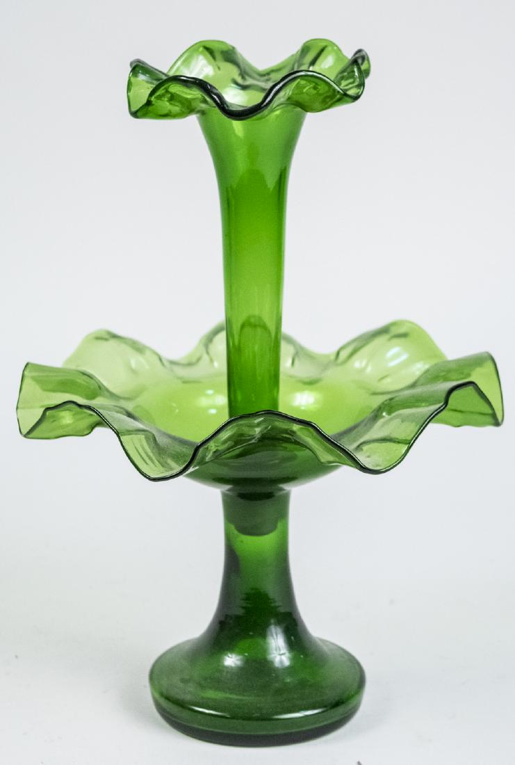 Green Glass Epergne: Two tiers. Height 14 inches. Notice to bidders: Condition reports and additional photographs are provided by request as a courtesy to our clients, as such any condition report is only an opinion and s