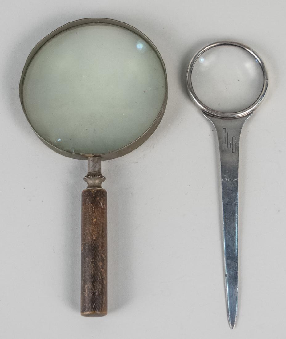 Two Magnifiers: One, a sterling silver paper knife with magnifier, the other with wood handle. Silver, length 9 inches. Notice to bidders: Condition reports and additional photographs are provided by request as a cou
