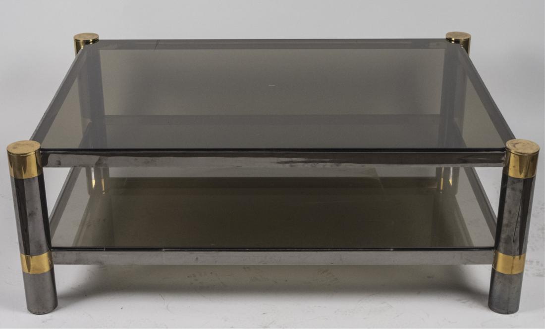 Karl Springer Two Tier Coffee Table: Metal and brass frame with inset rectangular glass top, four cylindrical legs joined by a conforming glass shelf. Height 17 inches, width 36 inches, depth 48 inches. Notice to bidders: Condition repor
