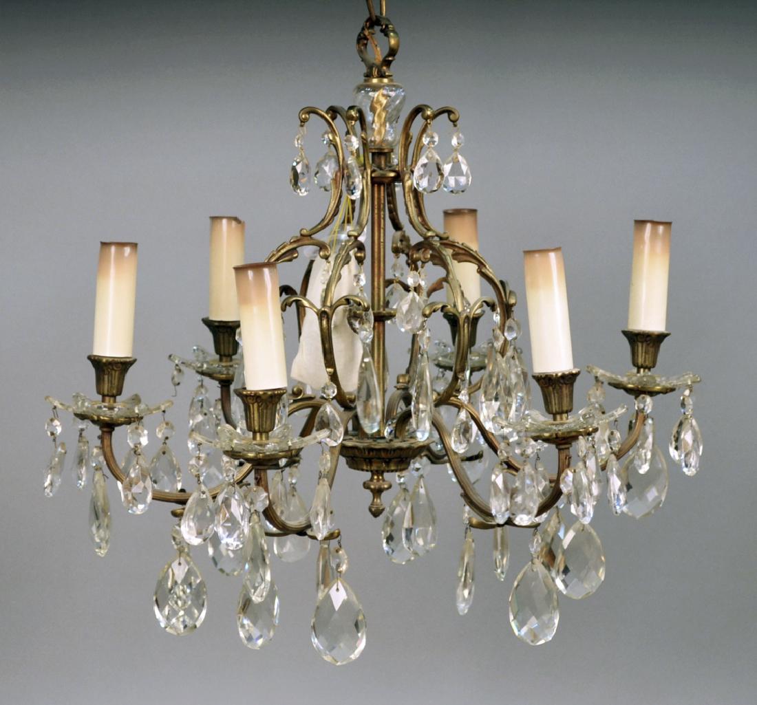Louis XVI Style Brass Chandelier: Six arms with faceted crystal pendants and crystal bobeche. Height 20 inches, diameter 24 inches. Notice to bidders: Condition reports and additional photographs are provided by request as a courtesy 