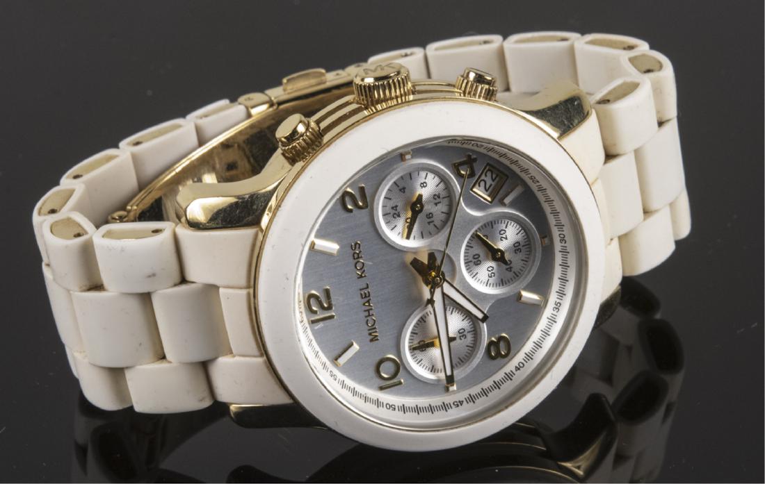 Michael Kors Wristwatch: Silvered metal dial with Arabic numerals, sweep seconds hand, three subsidiary dials and date aperture, white rubber band, in original box. Notice to bidders: Due to the nature of this particular onli