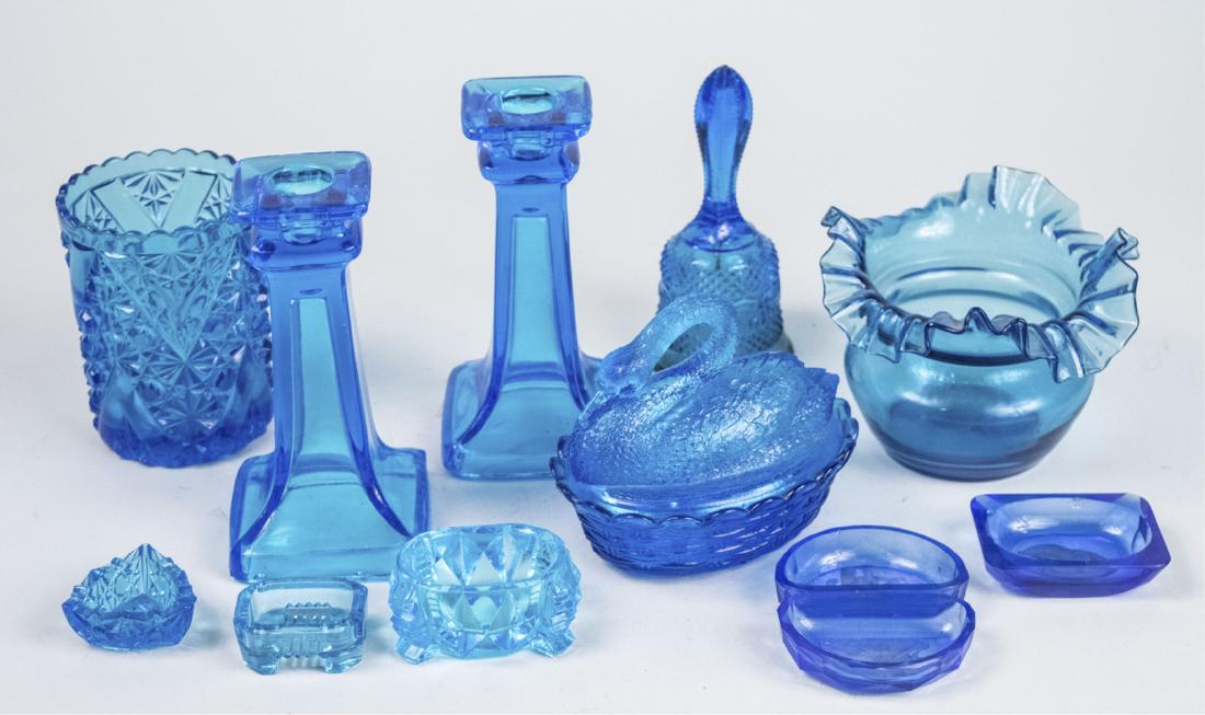 Group of Blue Glass Table Decorations: Ten pieces, including a pair of candlesticks, a swan dish, bell, etc. Pair of candlesticks, height 6 1/2 inches. Notice to bidders: Due to the nature of this particular online sale, the lots offered m