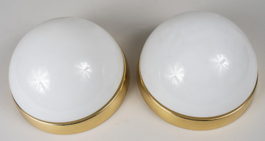 Pair of Ceiling Lights: Each with white glass shade and brass mounting plate. Diameter, 9 inches. Notice to bidders: Due to the nature of this particular online sale, the lots offered may not be available for detailed condit