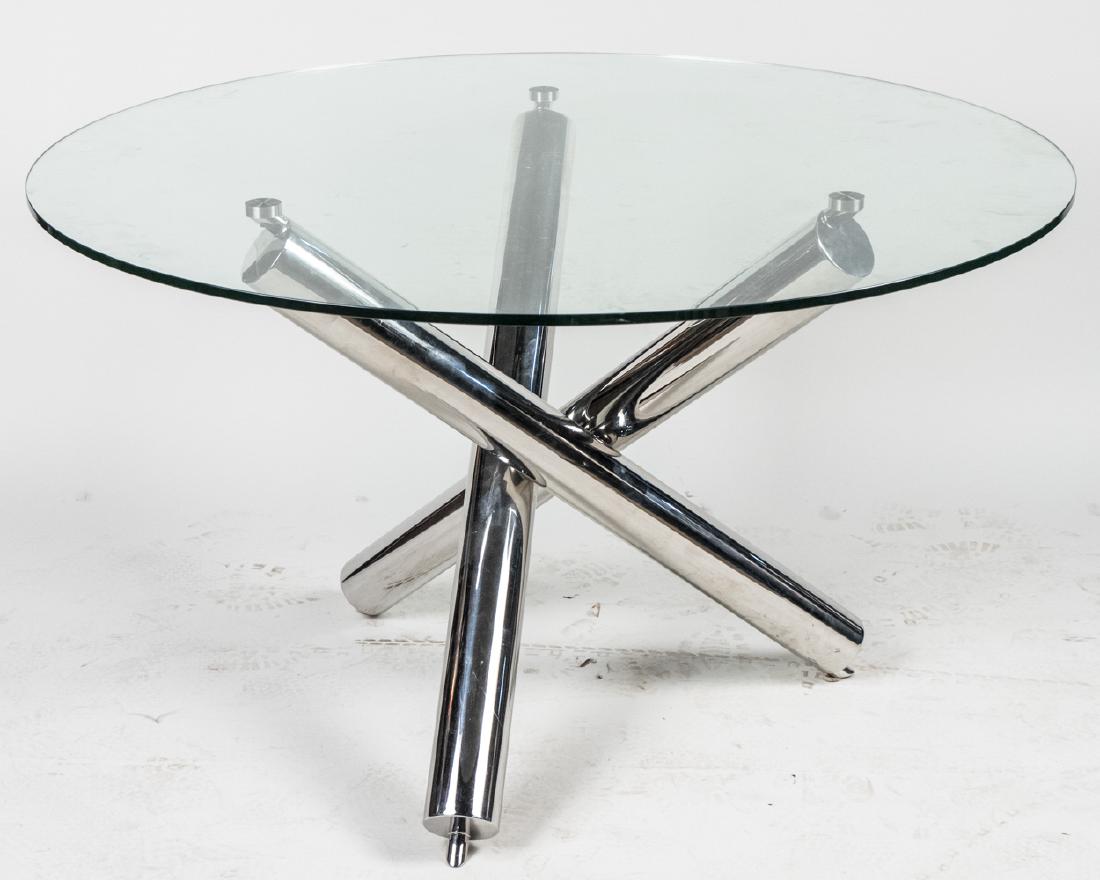 Brueton Style Glass Top Dining Table: Circular glass top on a polished steel, tripod base. Height 30 inches, diameter 48 inches. Notice to bidders: Due to the nature of this particular online sale, the lots offered may not be available fo