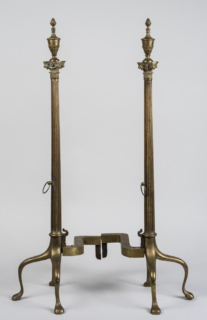 Pair of Brass Andirons: Reeded tapered columns capped with urns. Height 36 inches. Notice to bidders: Due to the nature of this particular online sale, the lots offered may not be available for detailed condition reports or 