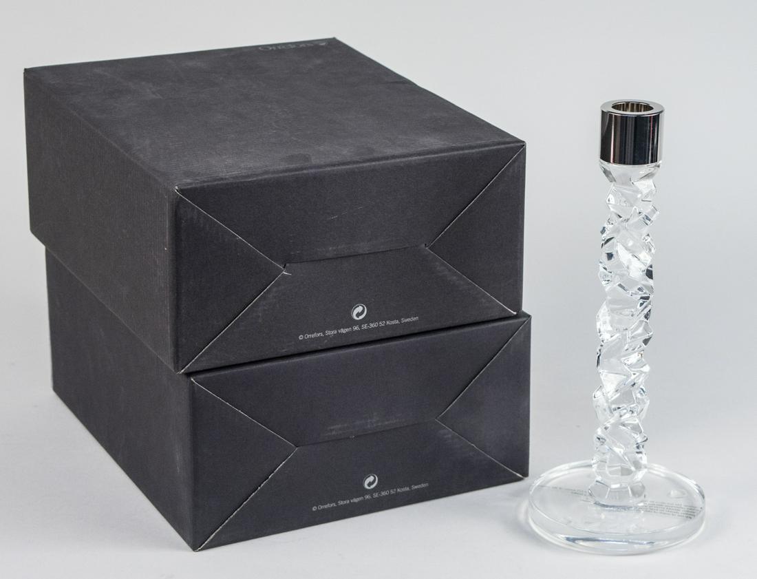 Orrefors Two Pairs of Candlesticks: New in box. Height 9 1/2 inches. Notice to bidders: Due to the nature of this particular online sale, the lots offered may not be available for detailed condition reports or additional photography. Th