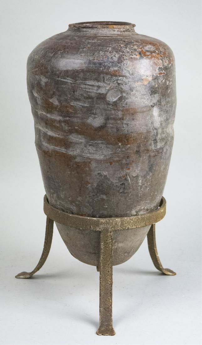 Pottery Amphora: On a metal stand. Overall height 23 inches. Notice to bidders: Due to the nature of this particular online sale, the lots offered may not be available for detailed condition reports or additional phot
