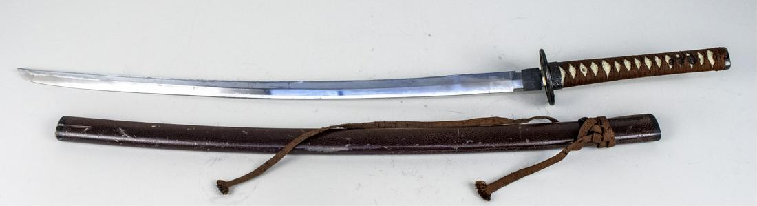 Reproduction Japanese Katana: The single edged slightly curved parade finished blade with bronzed tsuba (guard) and mounts with dragon and cloud decoration, cord wrapped faux shagreen grip, and scabbard with crackle finish. Blade 