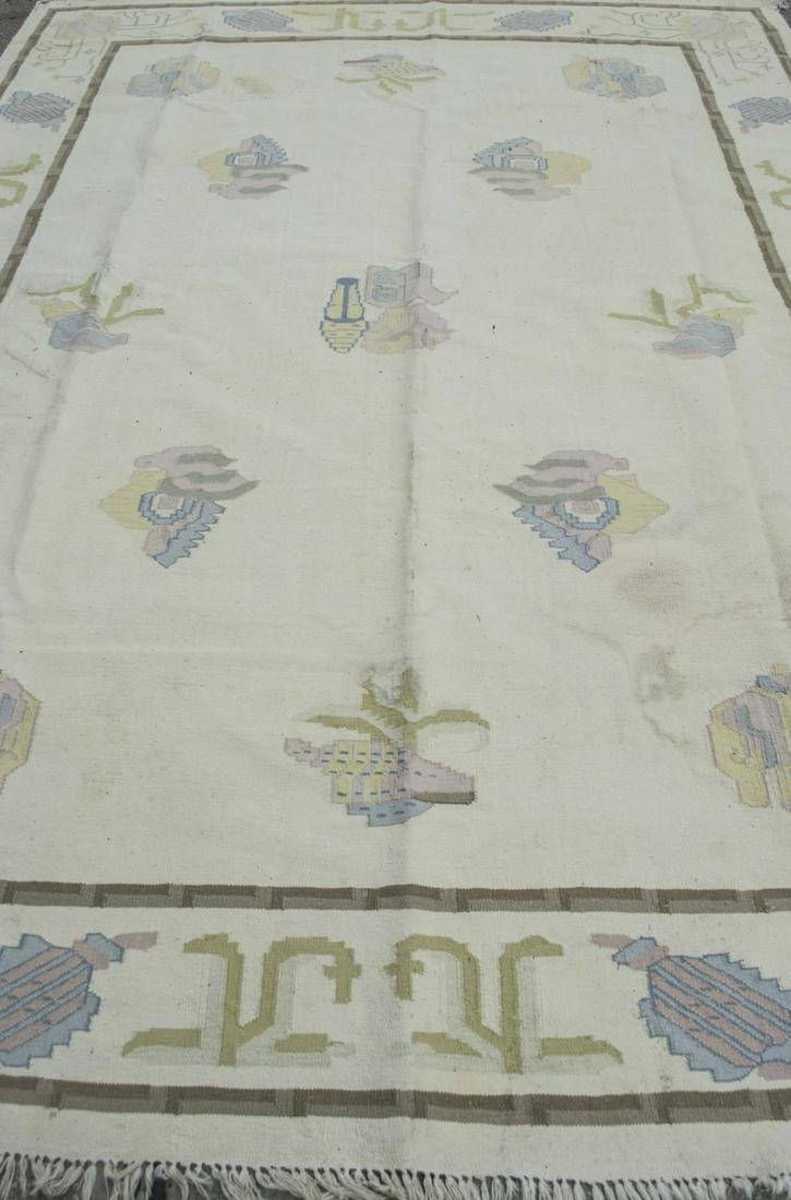 Flatweave Carpet: Allover stylized seashell and floral decoration on an ivory field within a border with similar decoration. 11 feet 3 inches x 8 feet 4 inches. Notice to bidders: Due to the nature of this particular o
