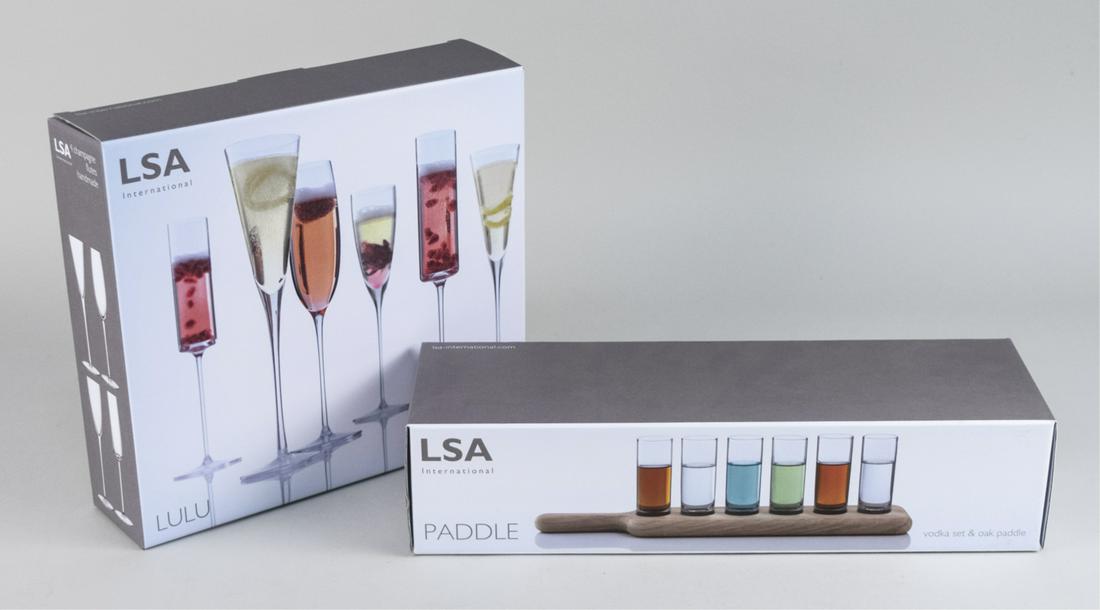 LSA International Vodka Set & Champagne Flutes: Includes a set of six shot glasses with serving paddle, and a box set of Lulu champagne flutes, in original boxes. Notice to bidders: Condition reports and additional photographs are provided by reque