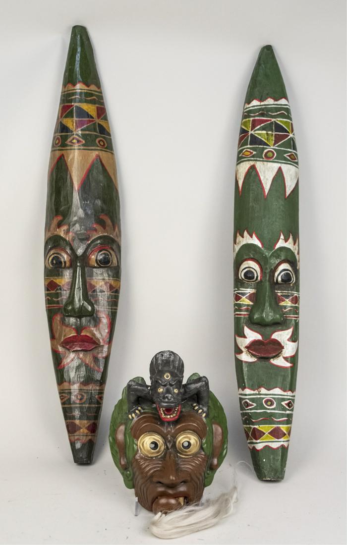 Three Indonesian Carved Wood Decorations: Three masks. Tallest 37 inches. Notice to bidders: Due to the nature of this particular online sale, the lots offered may not be available for detailed condition reports or additional photography. The