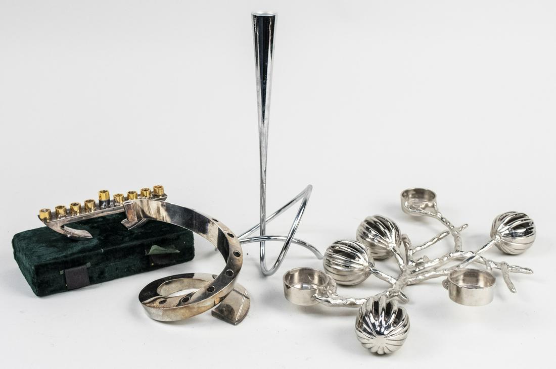 Four Metal Candlesticks: Including a Dansk candelabra, a menorah, etc. Various sizes. Notice to bidders: Condition reports and additional photographs are provided by request as a courtesy to our clients, as such any condition