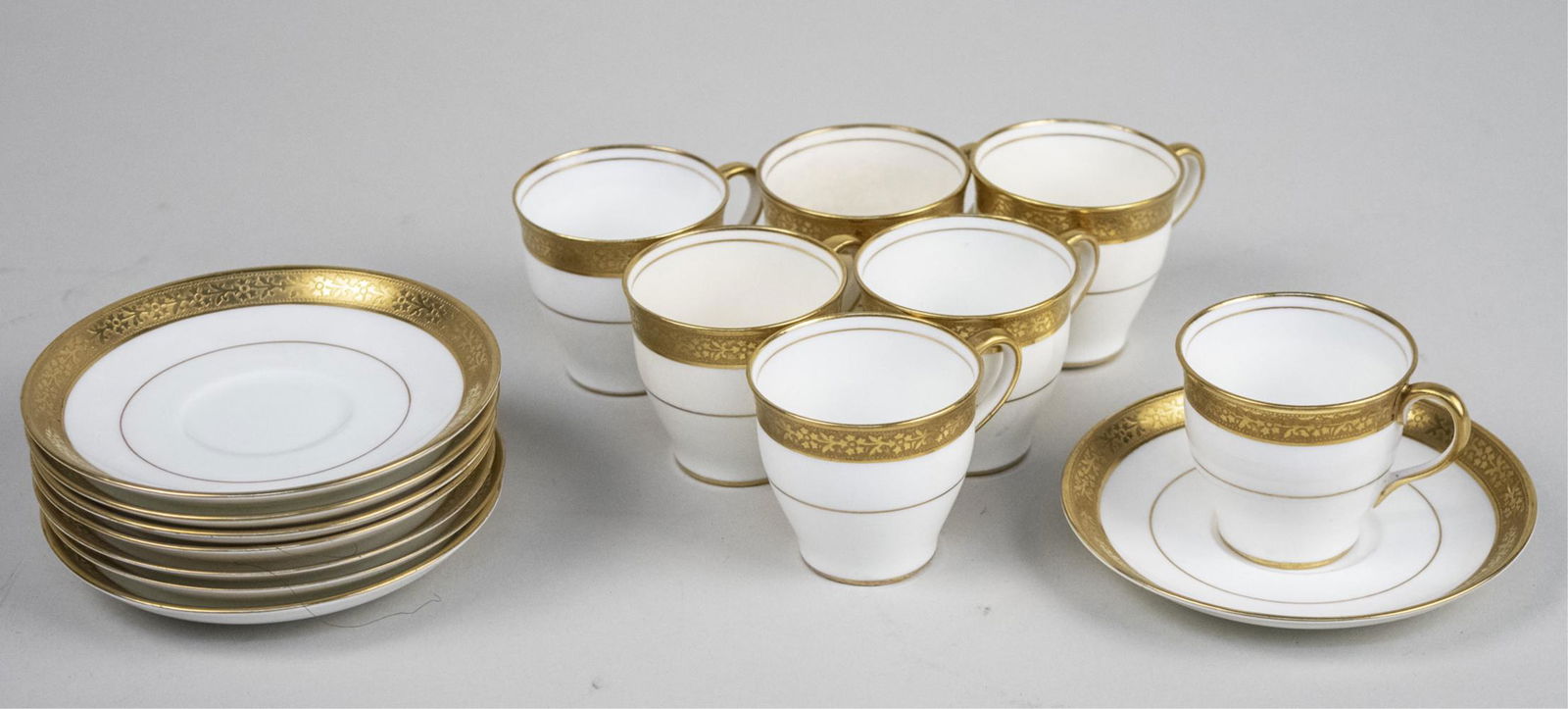 Aynsley English Porcelain Demitasse Set: Pattern 4982, with floral encrusted gold band edge, including seven cups and eight saucers. Notice to bidders: Due to the nature of this particular online sale, the lots offered may not be available f