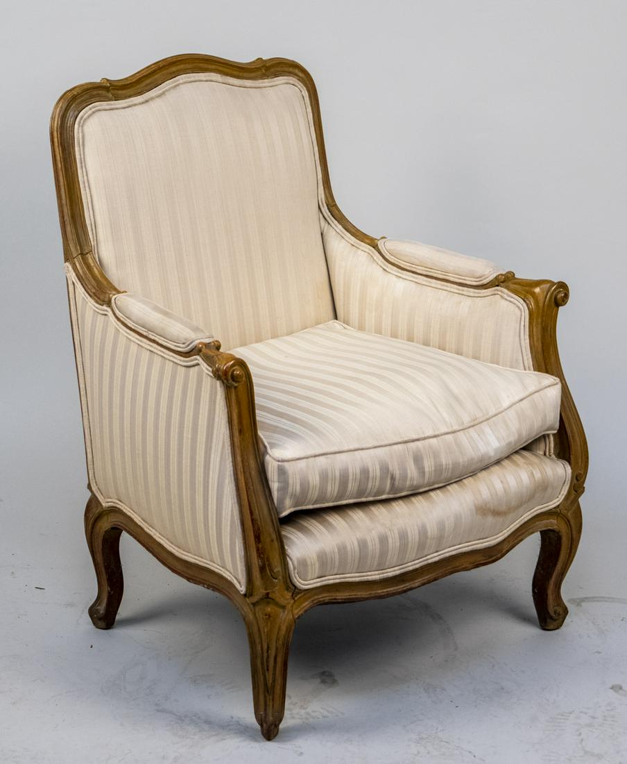 Louis XV Style Beechwood Bergere: Cream colored satin striped upholstery. Height 34 inches, width 28 inches, depth 25 inches. Notice to bidders: Condition reports and additional photographs are provided by request as a courtesy to our