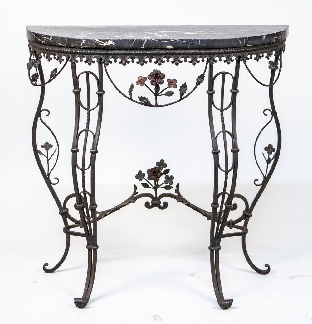 Marble Top Wrought Iron Console Table: White veined black marble D shaped top, on a scroll and floral iron base. Height 30 inches, width 30 inches, depth 11 inches. Notice to bidders: Condition reports and additional photographs are provid