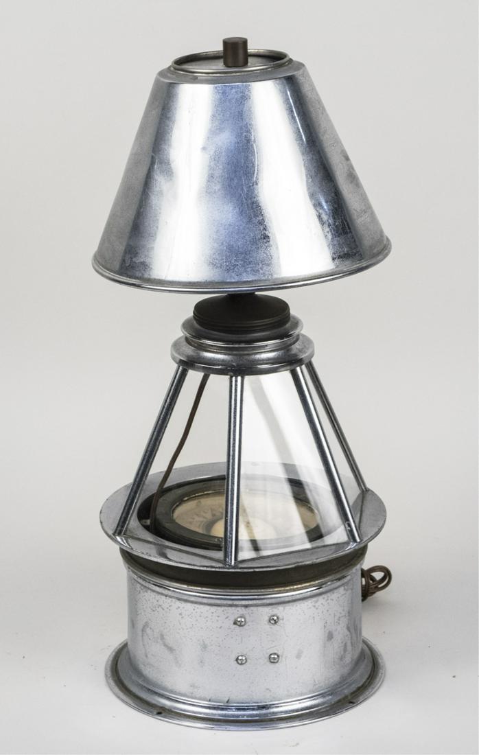Marine Compass Mounted as a Lamp: Chrome lamp shade. Height overall, 21 inches. Notice to bidders: Condition reports and additional photographs are provided by request as a courtesy to our clients, as such any condition report is only